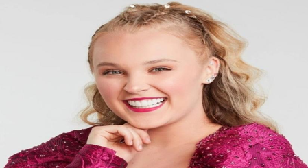 Chris Hughes gifts JoJo Siwa a bouquet of flowers at airport